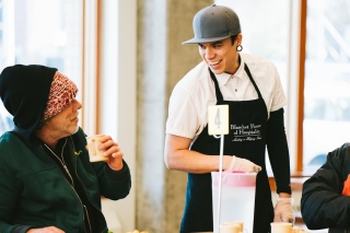 A Blanchet House worker smiling at a person during meal service