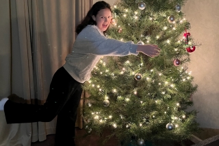 A girl hugging a Christmas tree with white lights