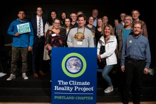 A group of people standing behind a The Climate Reality Project Portland Chapter podium