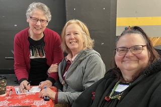 Three smiling people sitting together at a table