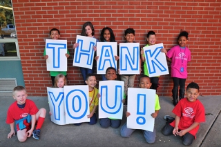 Kids holding up Thank You signage
