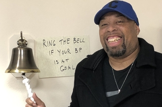 Photo of a Black man ringing a bell